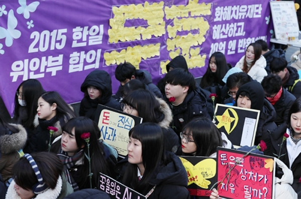 27일 오후 서울 종로구 옛 주한일본대사관 앞에서 정대협 주최로 열린 '일본군 위안부 문제 해결을 위한 정기 수요시위'에서 참가자들이 손팻말을 들고 있다.