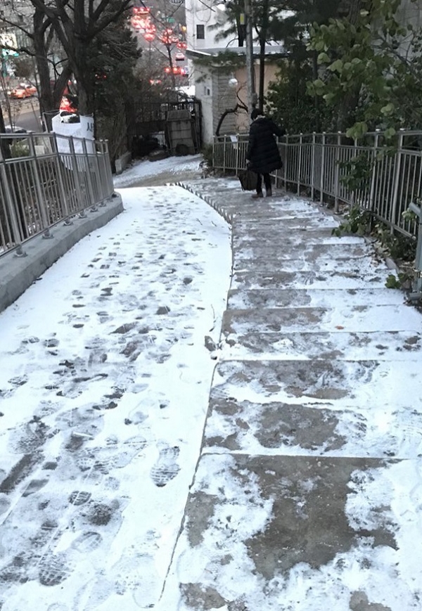 한파가 몰아친 9일 오전 출근길에 오른 한 시민이 서울 종로구의 빙판길 계단의 난관을 붙잡고 조심스럽게 내려가고 있다. (사진=연합뉴스)