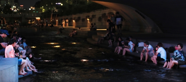 서울 청계천을 찾은 시민들이 물에 발을 담그고 더위를 식히고 있다. (사진=연합뉴스)