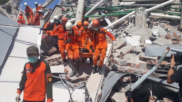 지난달 30일 팔루에서 구조대원들이 희생자들의 유해를 옮기는 모습. (사진=EPA/연합뉴스)