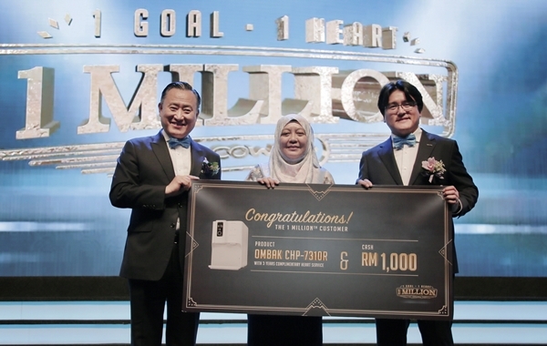 이해선 코웨이 대표이사(왼쪽)와 최기룡 코웨이 말레이시아 법인장(오른쪽)이 100만 번째 말레이시아 고객(가운데)에게 감사 인사를 전하며 기념 사진을 촬영하고 있다. (사진=코웨이)