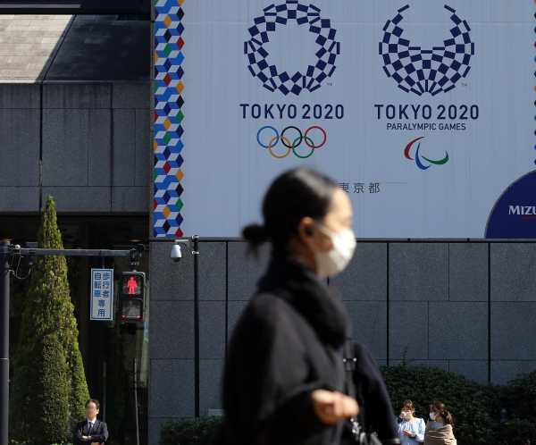 마스크를 쓴 여성이 도쿄 올림픽·패럴림픽 홍보물이 설치된 일본 도쿄도(東京都) 지요다(千代田)구의 한 사거리를 지나가고 있다. (사진=연합뉴스)