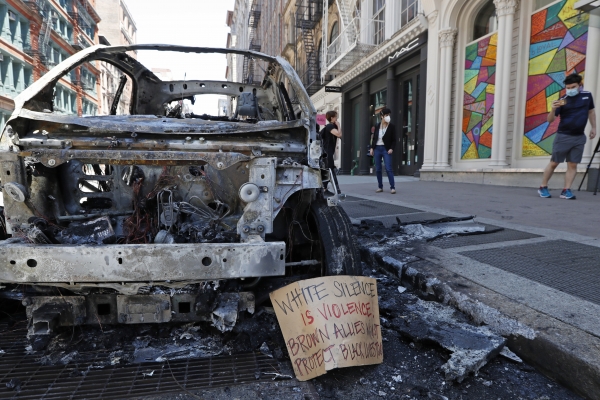 미국 뉴욕시 로어맨해튼의 브로드웨이 거리에서 31일(현지시간) 불에 탄 채 방치된 차량의 잔해에 메시지가 놓여있다. (사진=AP/연합뉴스)