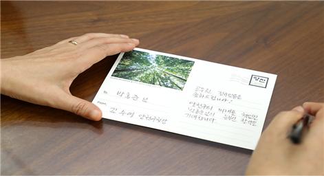 김수영 양천구청장이 8월 1일 정식 임용되는 12명 시보 공무원에게 축하 엽서를 작성하고 있다.(사진=양천구)