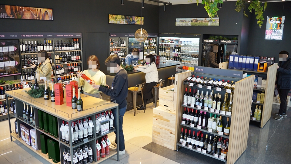 세븐일레븐의 와인 전문 콘셉트숍 '와인스튜디오'에서 소비자들이 와인을 살피고 있다.[사진=코리아세븐]