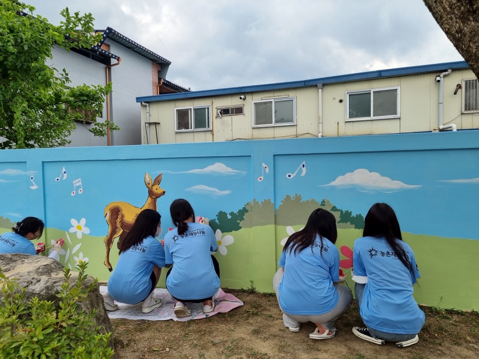 농촌재능나눔 캠프에 참여한 대학생들이 농촌마을 벽화그리기를 하고 있다. [사진=농어촌공사]
