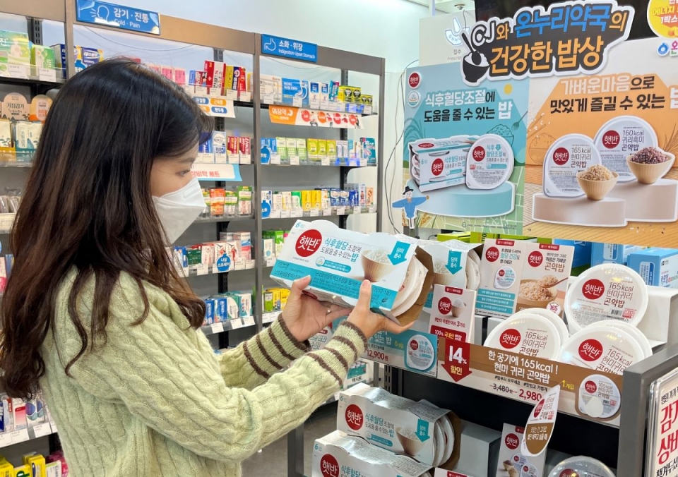 한 소비자가 온누리약국에서 판매를 개시한 햇반의 식후혈당밥 제품을 살펴보고 있다. [사진=CJ제일제당]