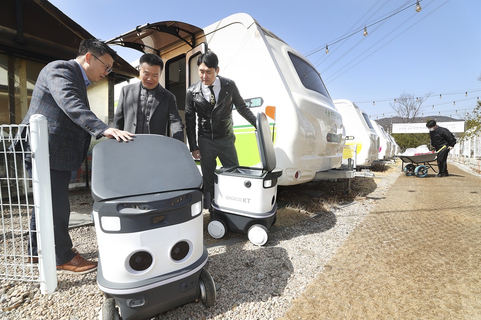 (왼쪽부터) 이상호 KT AI Robot사업단장과 최종석 캠핑톡 대표, 김정환 캠핑아웃도어 대표가 KT 자율주행 배송로봇을 살펴보고 있다.[사진=KT]