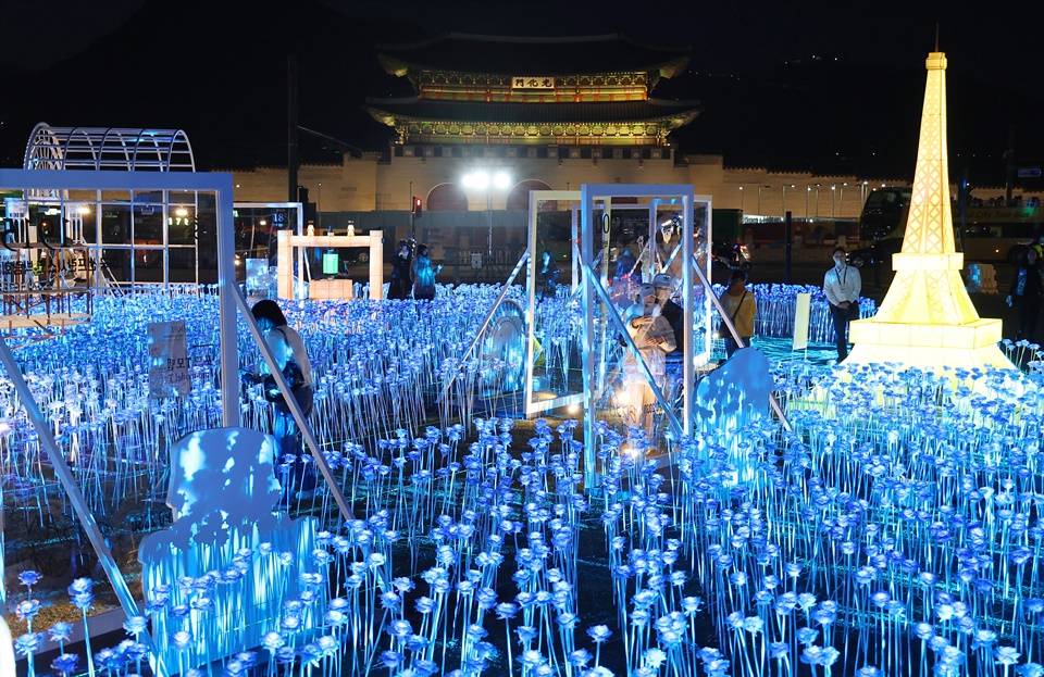 30일 오후 서울 종로구 광화문 광장에 마련된 2030 부산세계박람회(EXPO) 유치 기원 점등식을 찾은 시민들이 불 밝힌 LED 장미를 살펴보고 있다.[사진=연합뉴스]