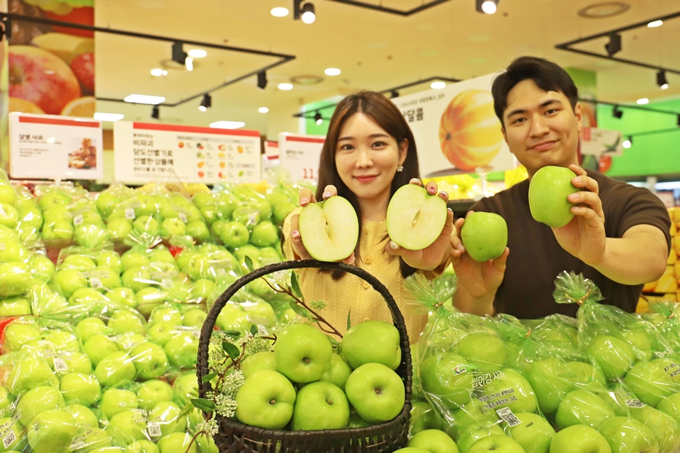 모델들이 롯데마트 서울역점에서 썸머킹 사과를 들고 홍보하고 있다.[사진=롯데쇼핑]