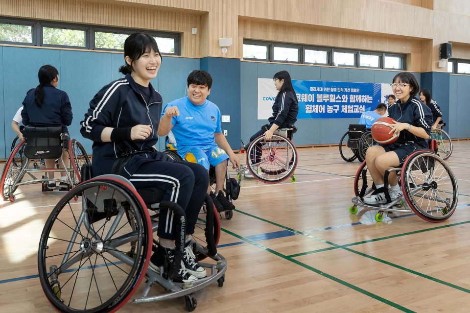 코웨이 블루휠스 휠체어농구단이 관악구 영락고등학교를 찾아 청소년을 위한 장애 인식 개선 캠페인을 진행했다. 영락고등학교 학생들이 휠체어농구를 체험하고 있다.[사진=코웨이]