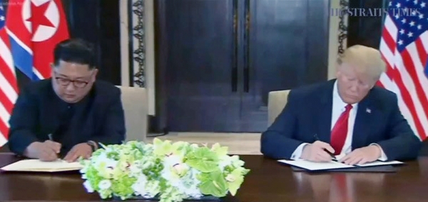 역사적 첫 북미정상회담이 열린 12일 오전 싱가포르 센토사 섬 카펠라호텔에서 미국 도널드 트럼프 대통령과 북한 김정은 국무위원장이 합의문에 서명하고 있다. (사진=스트레이츠타임스 홈페이지 캡처)