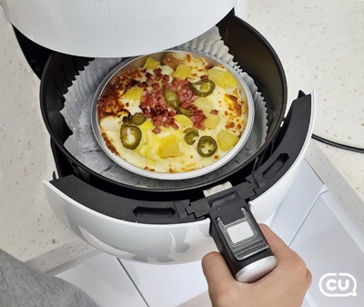 한 소비자가 CU 떠먹는 피자를 에어프라이어로 조리하고 있다.(이미지=BGF리테일)