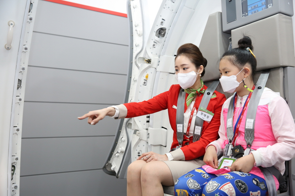5일 어린이날 서울 강서구 티웨이항공 훈련센터에서 열린 ‘항공의 꿈을 만나다’ 행사에 참가한 초등학생 어린이가 안전 훈련 체험에 참여하는 모습. [사진=티웨이항공]