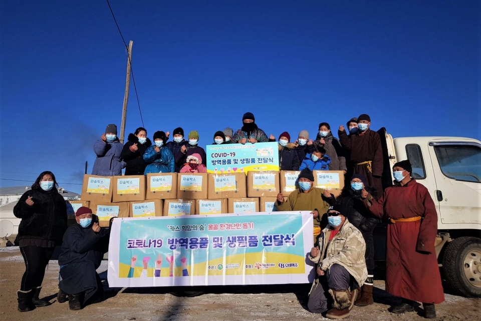 몽골 카스 희망의 숲 인근 하늘마을 주민들이 푸른아시아의 현지 활동가와 따숨박스 전달식에 참석해 기념사진을 찍고 있다. [사진=오비맥주]
