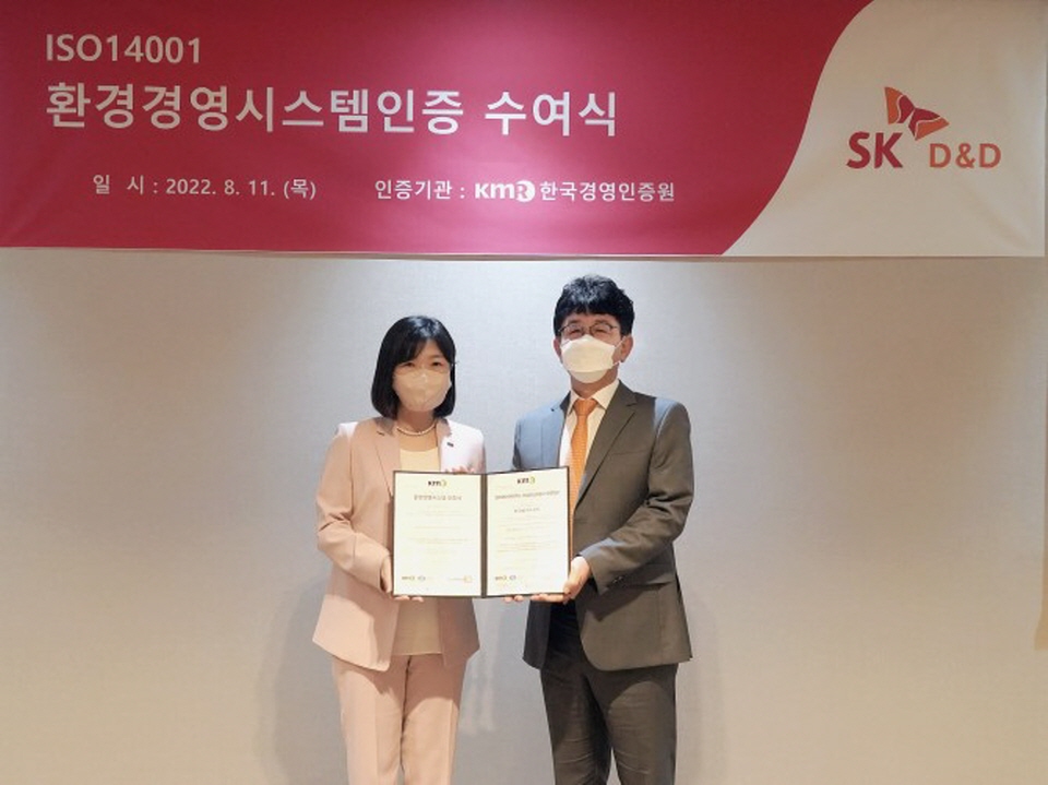 황은주 한국경영인증원 대표(왼쪽)와 황선표 SK디앤디 지속가능경영위원회 위원(오른쪽)이 지난 11일 SK디앤디 ISO 14001 인증서 수여식에서 기념 촬영하는 모습. [사진=SK디앤디]