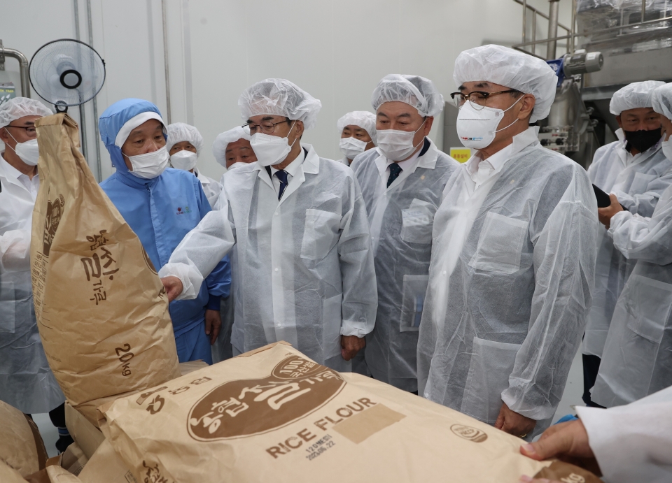 이성희 농협중앙회장(왼쪽 세번째) 지난 22일 경남 밀양 소재 오리온농협 본사를 찾아 제품 생산에 사용할 쌀가루를 살펴보고 있다. [사진=농협]