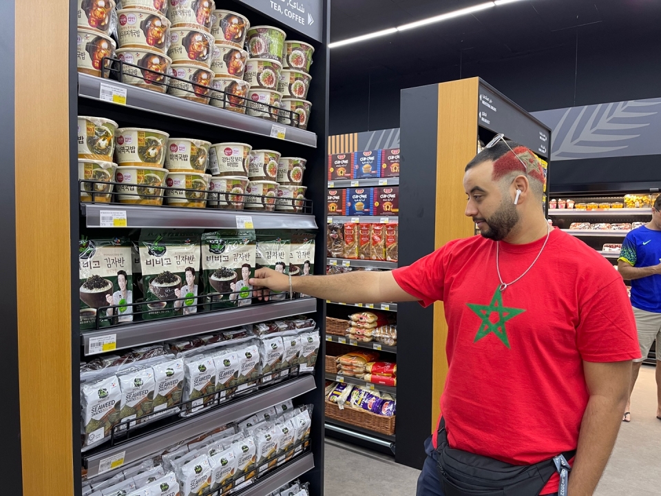카타르의 한 축구팬이 경기장 인근 월드컵 팬 존에서 CJ제일제당의 비비고 제품을 살펴보고 있다. [사진=CJ제일제당]