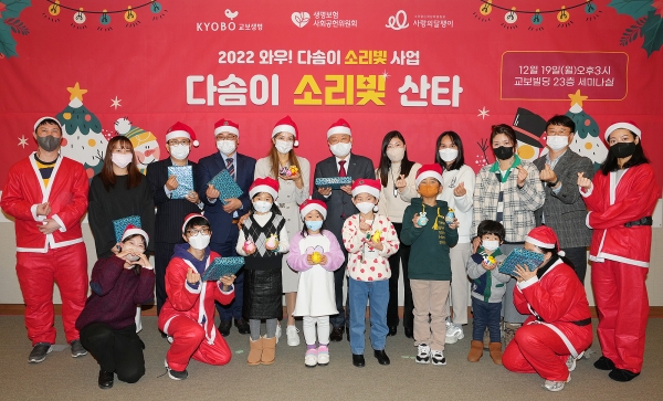 교보생명 임직원 등 자원봉사자들이 지난 19일 서울 종로구 교보빌딩에서 열린 '다솜이 소리빛 산타' 행사에서 기념 촬영을 하고 있다. (사진=교보생명)