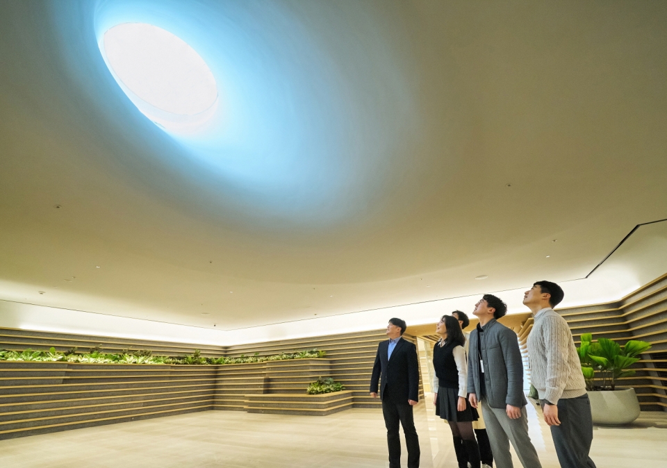 LG 직원들이 LG트윈타워 지하 1층에 새로 조성된 ‘틴들(Tyndall)’에서 햇빛이 들어오는 천장을 바라보고 있다.[사진=LG]